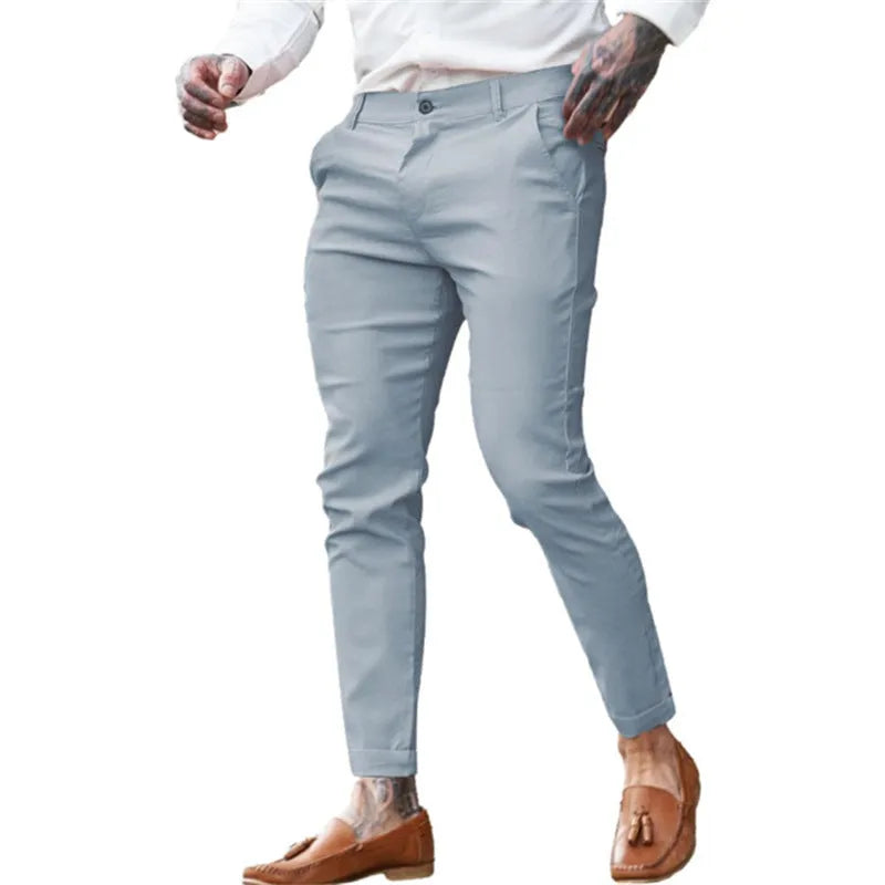 Men's slim-fit pencil trousers in high elasticity cotton twill fabric on a grey background.