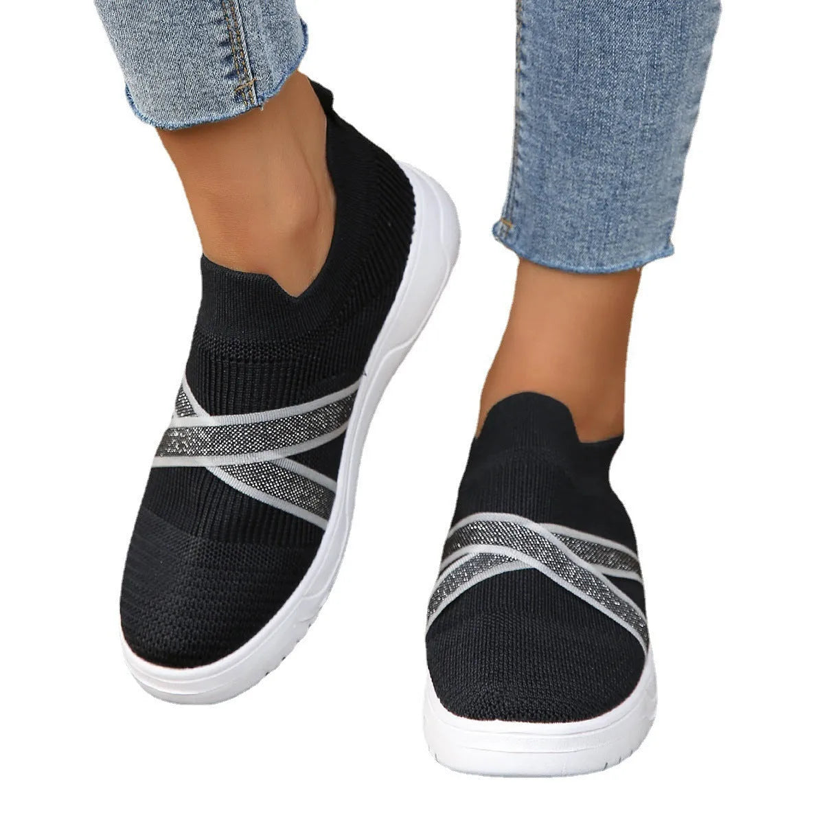 Black women's Flyknit mesh flat shoes with a tassel detail on the low-top upper and a flat rubber sole.