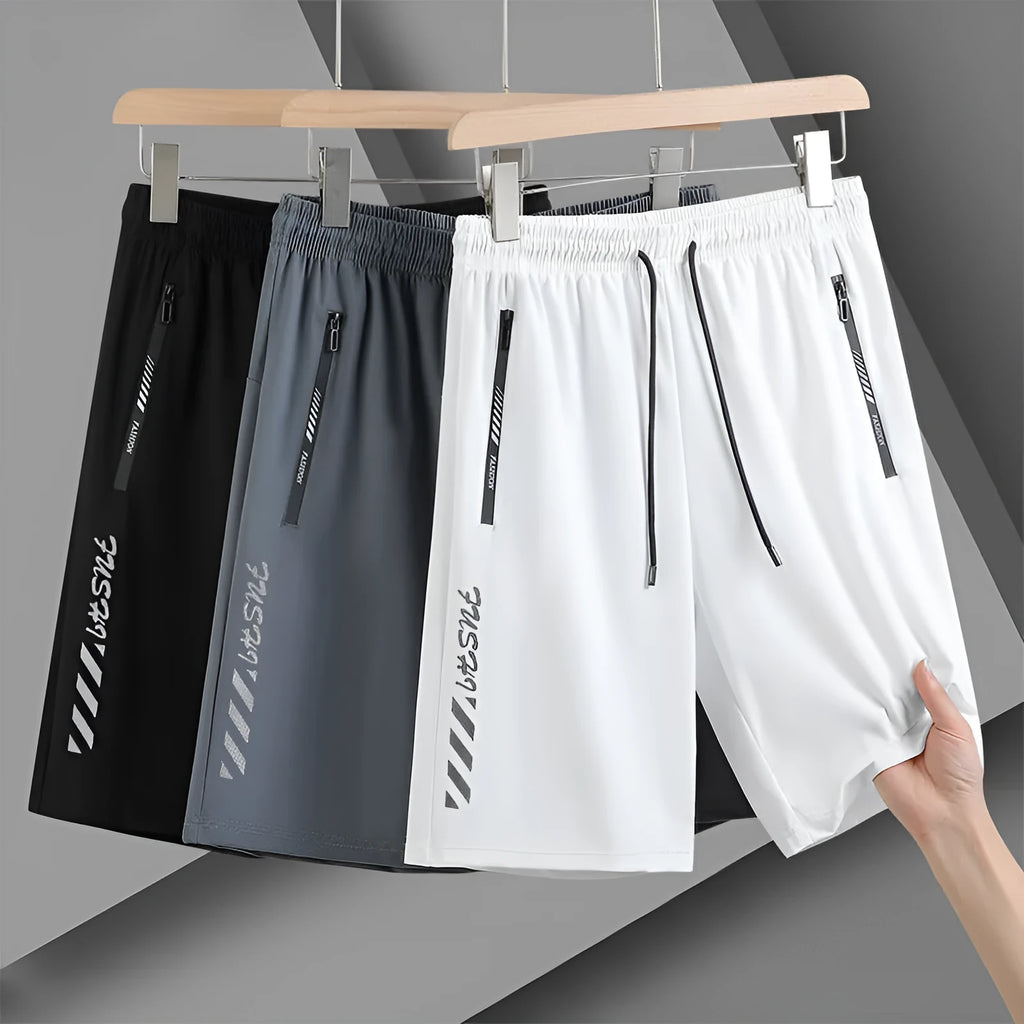 Man wearing black loose-fit quick-drying nylon sports shorts for summer activity.