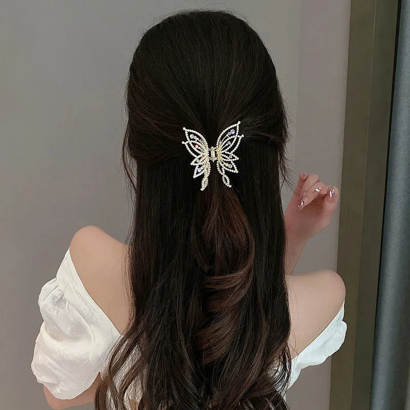 Butterfly-shaped alloy hair clip with electroplated finish in pearl or rhinestone style.