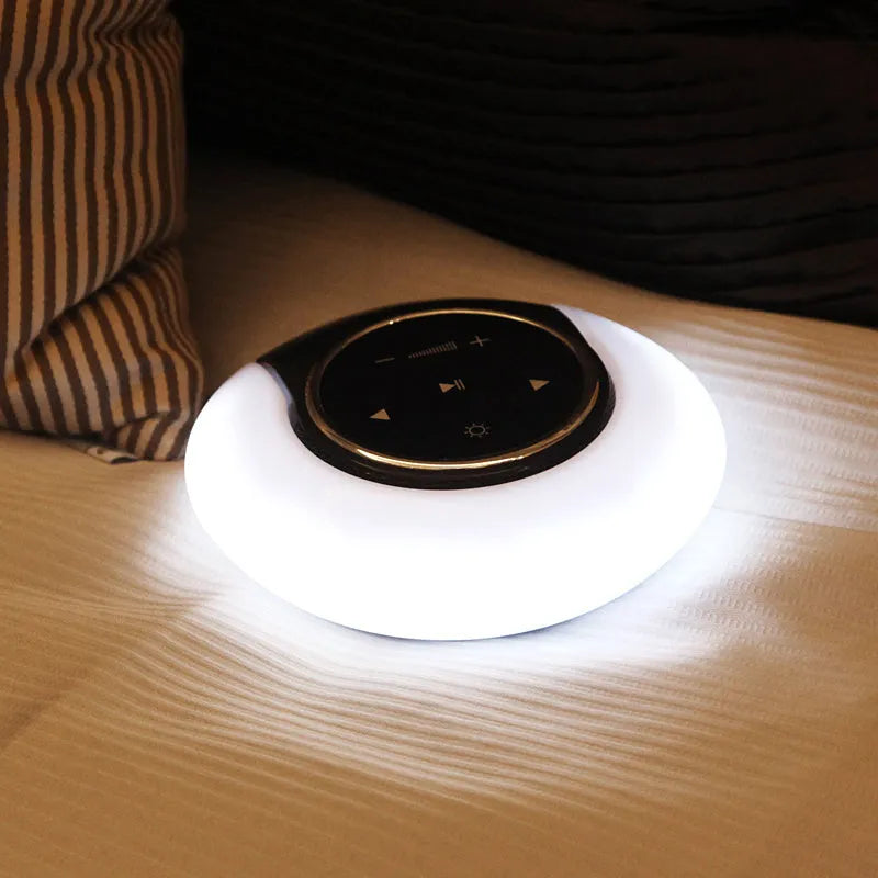 Blue cubic Bluetooth desk lamp speaker with touch controls and folding head on wooden desk