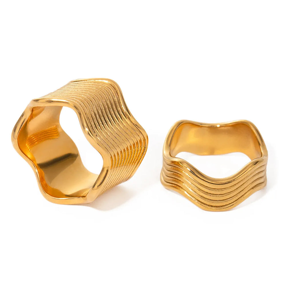 Silver-toned stainless steel women's ring with a wide geometric wave pattern.