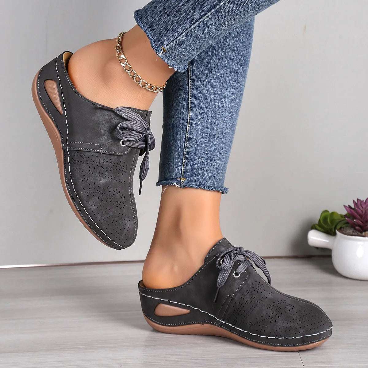 Women's black lace-up wedge slippers with suede upper and hollow-out design on a rubber sole.