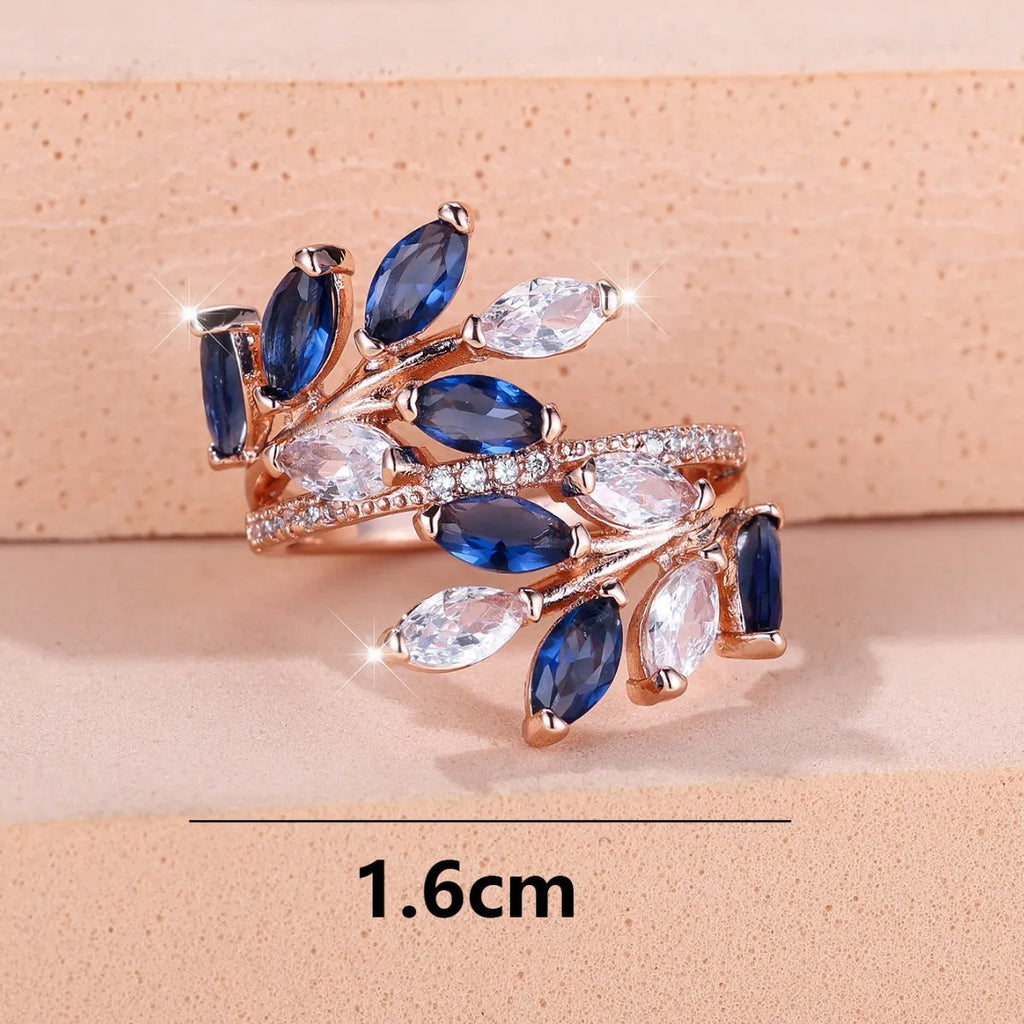 Adjustable copper leaf-shaped ring with zircon gemstone colour options on a white background.