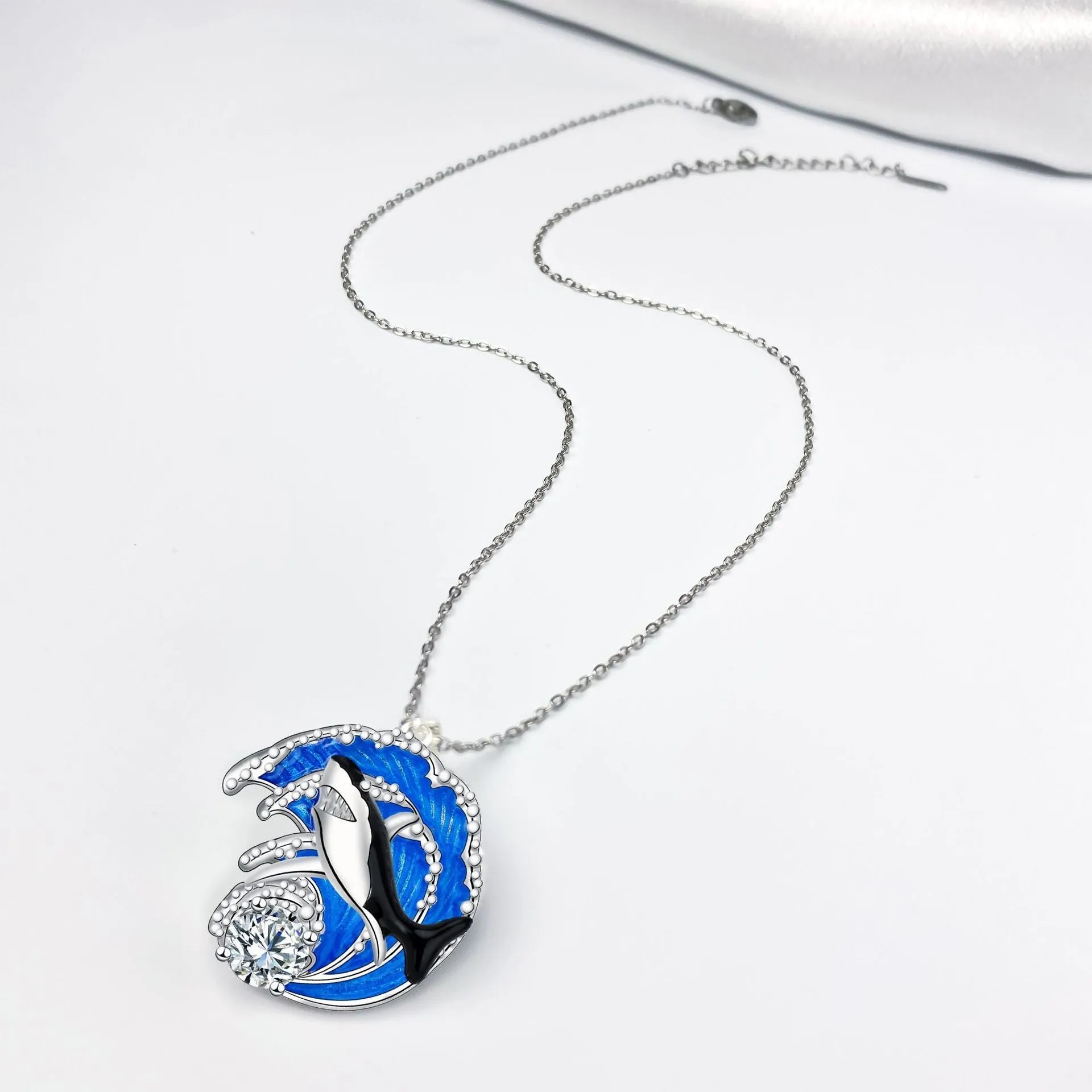 Silver shark pendant necklace on a cross chain, adjustable between 41cm and 50cm.