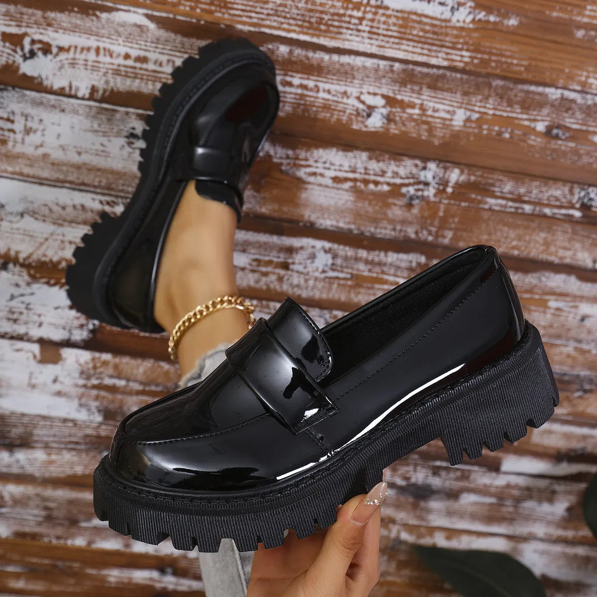 Women's black slip-on loafers with a chunky platform heel and rubber sole on a neutral background.