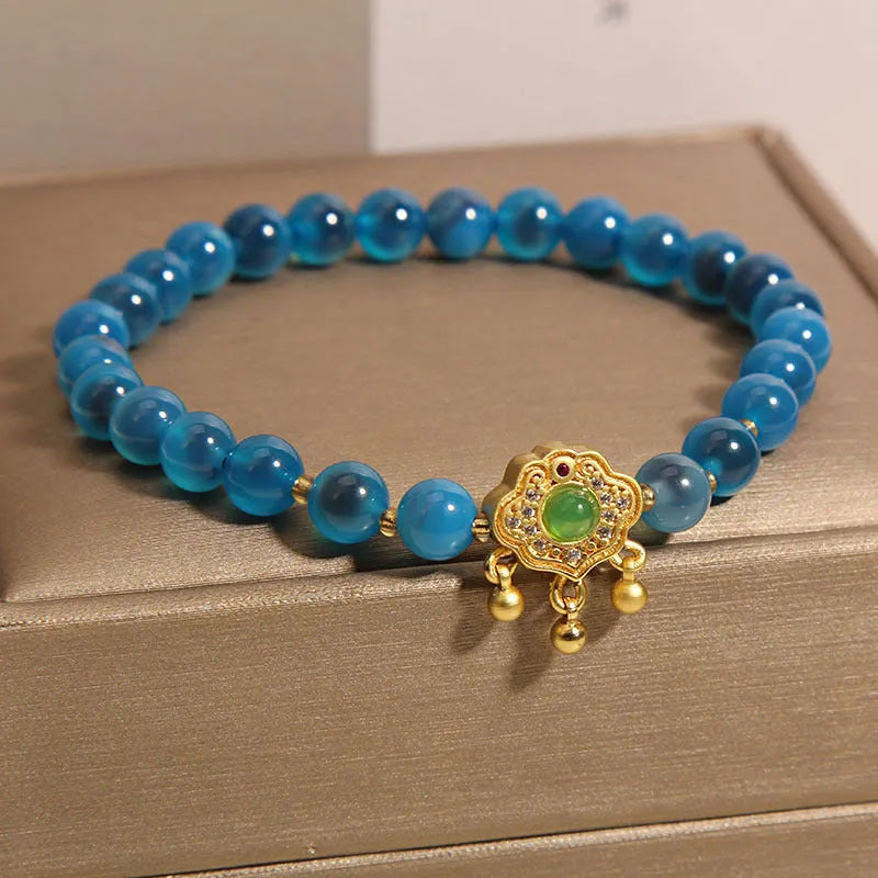 Blue sugar heart agate and jade safety lock pendant on a women's crystal bracelet with alloy inlay.
