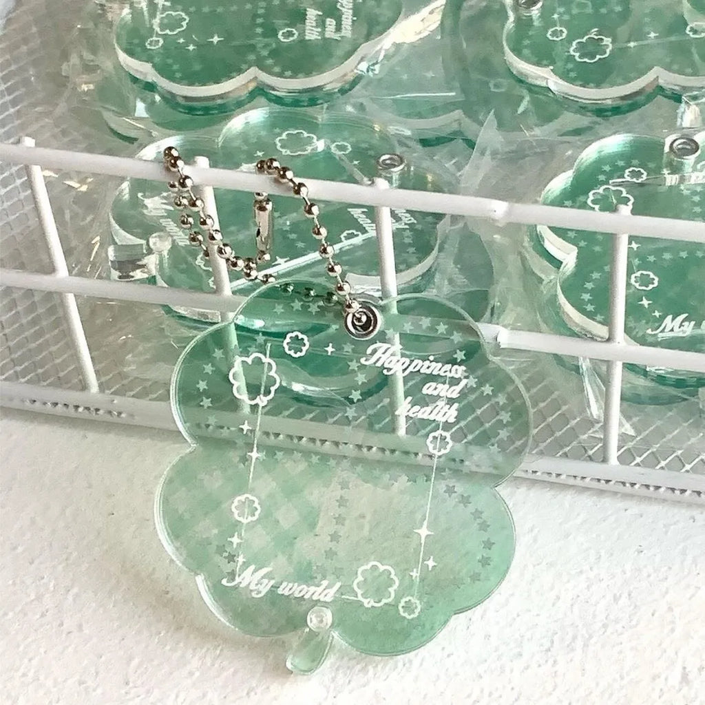 Blue four-leaf clover acrylic charm on a keychain ring.