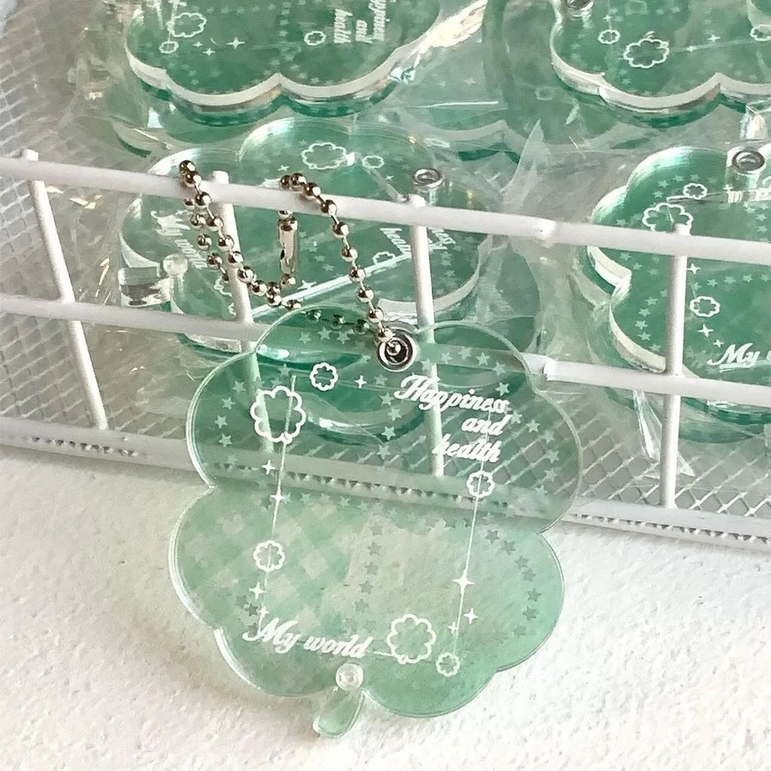 Blue four-leaf clover acrylic charm on a keychain ring.