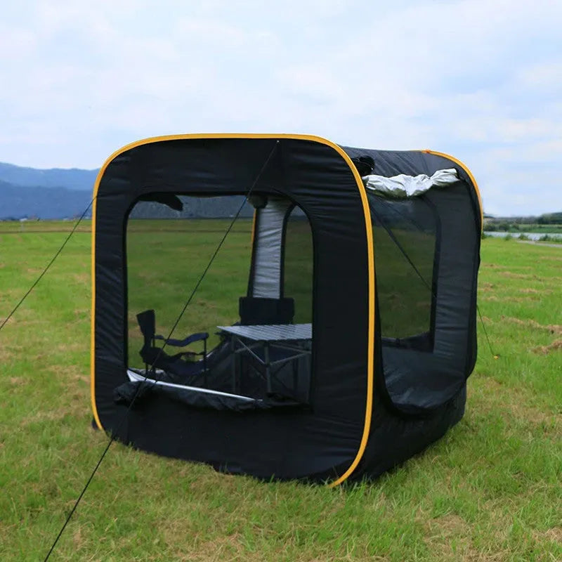 Black pop-up car tailgate camping tent unfolded next to a vehicle