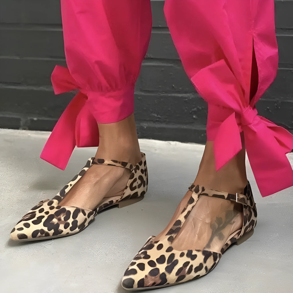 Leopard print women's pumps with pointed toe, chunky low heel, and ankle strap.