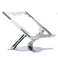Grey aluminium adjustable laptop stand holding a silver laptop on a wooden desk.
