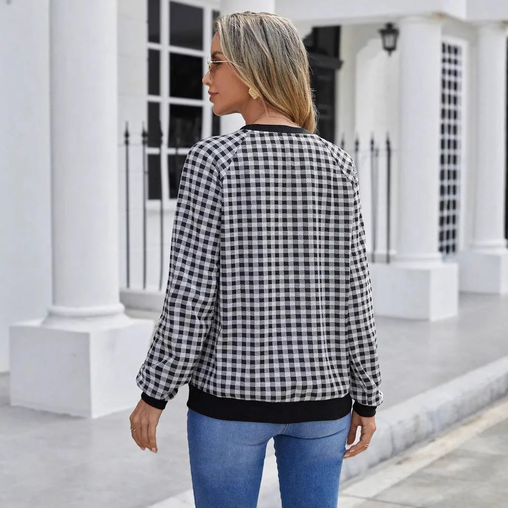 Black long sleeve plaid pullover sweater with Japanese style printing laid flat.