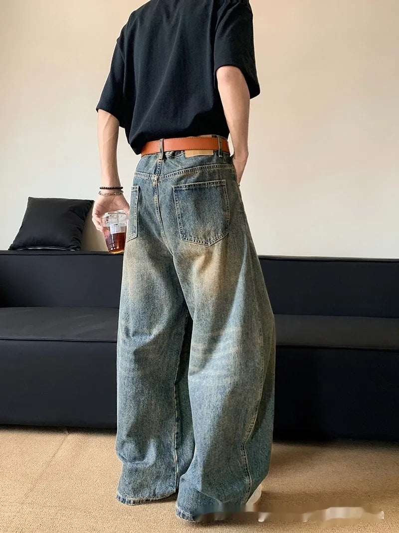 Men's distressed retro blue denim trousers with wide-leg silhouette and micro-elastic cotton-blend fabric