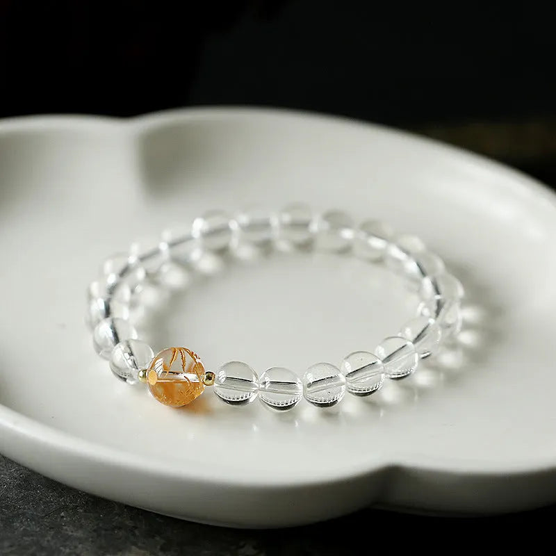Geometric obsidian white crystal bracelet with black agate beads and gold dragon charm on wrist
