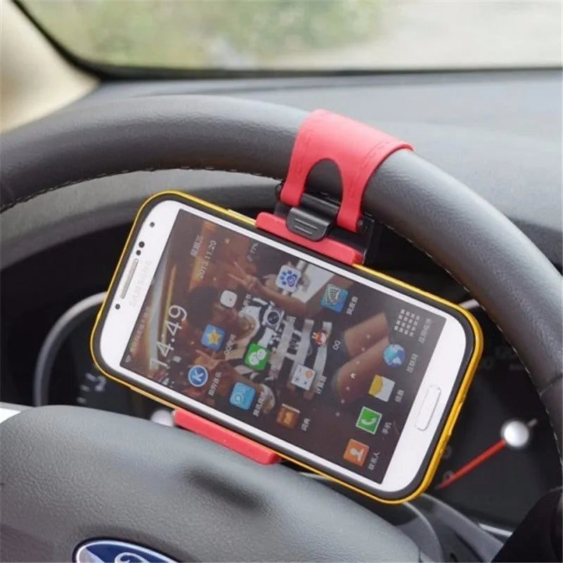 Black universal steering wheel phone holder clip mounted on a car steering wheel.