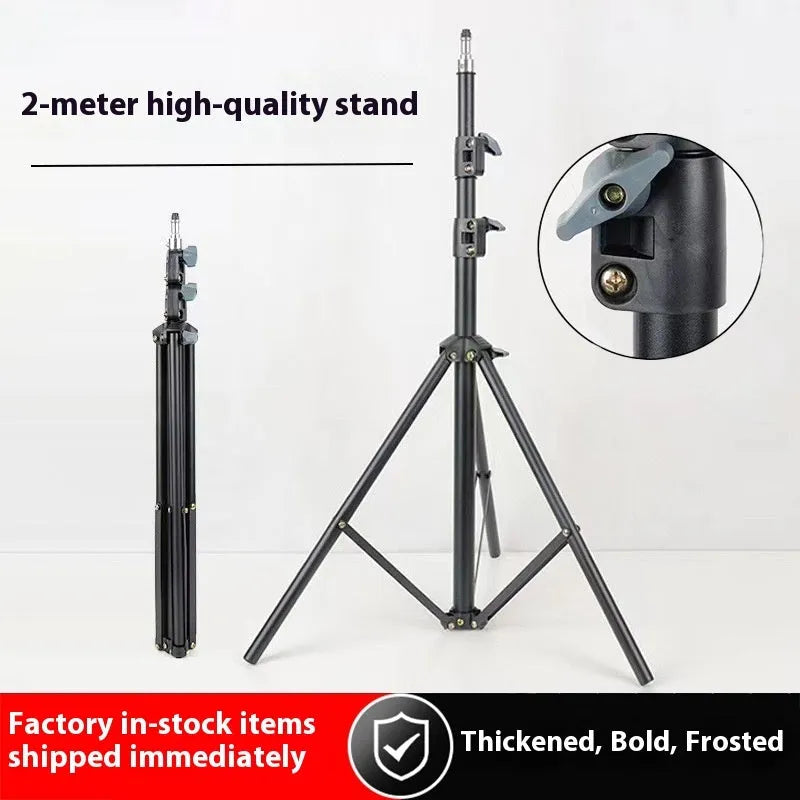 Tall black floor tripod stand holding a mobile phone extended to its full height on a wooden floor.