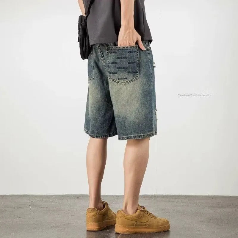 Men's blue denim shorts with retro loose hole distressing and a straight-leg cut.