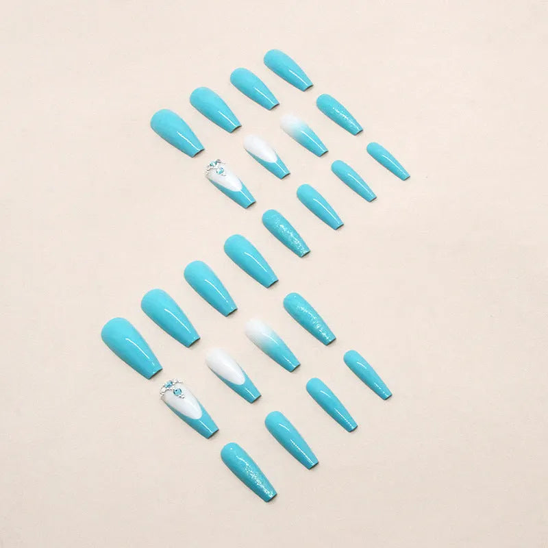 Long ballet false nails with smart blue diamond accents on solid colour background