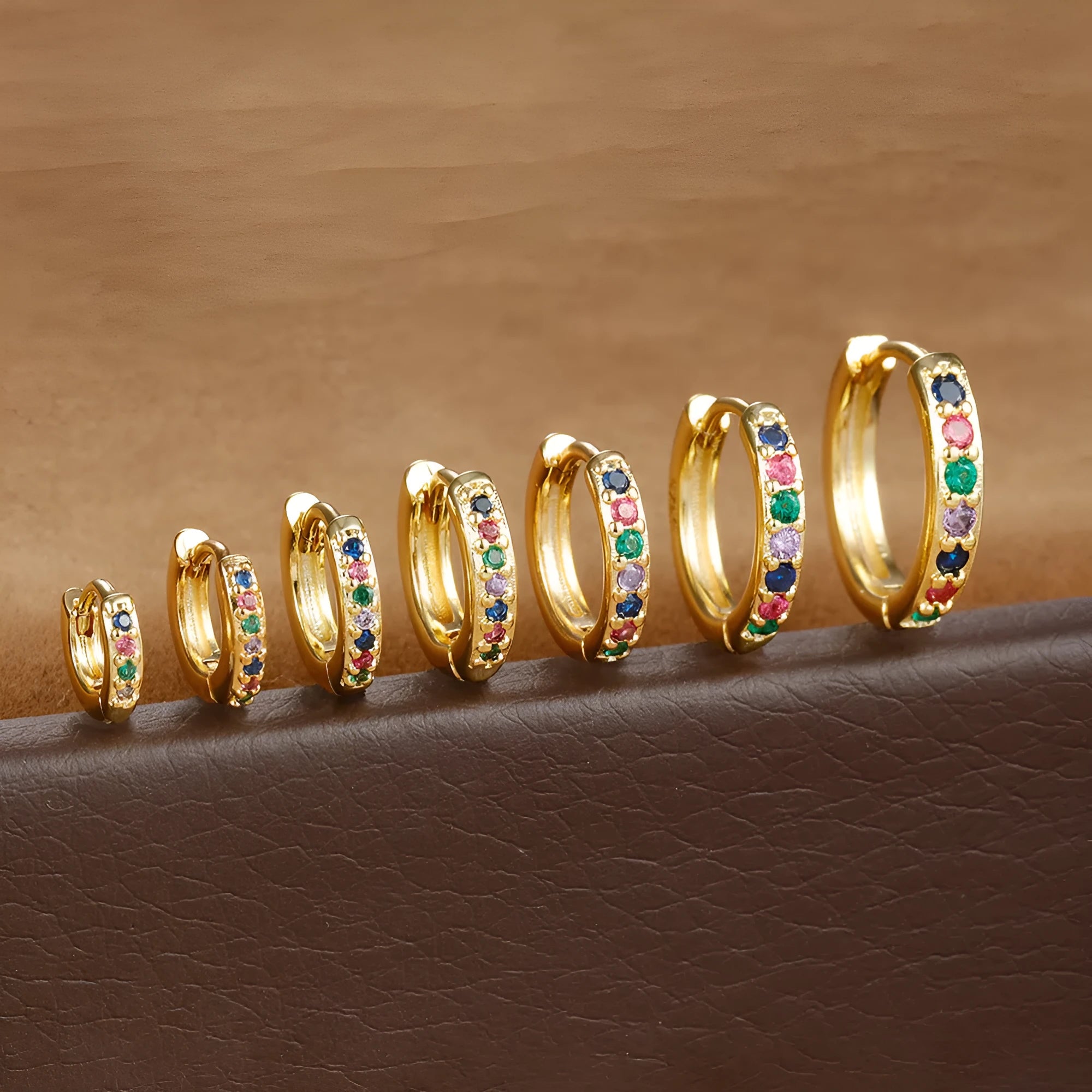 Gold, rose gold, and silver circle stud earrings with a perforated geometric design in various sizes.
