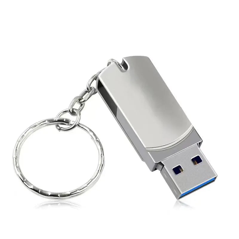 White metal USB flash drive with rotating cap shown next to a UK 10p coin for scale