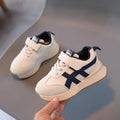 Children's white casual sneaker with Velcro fastening and rubber sole shown on size label.