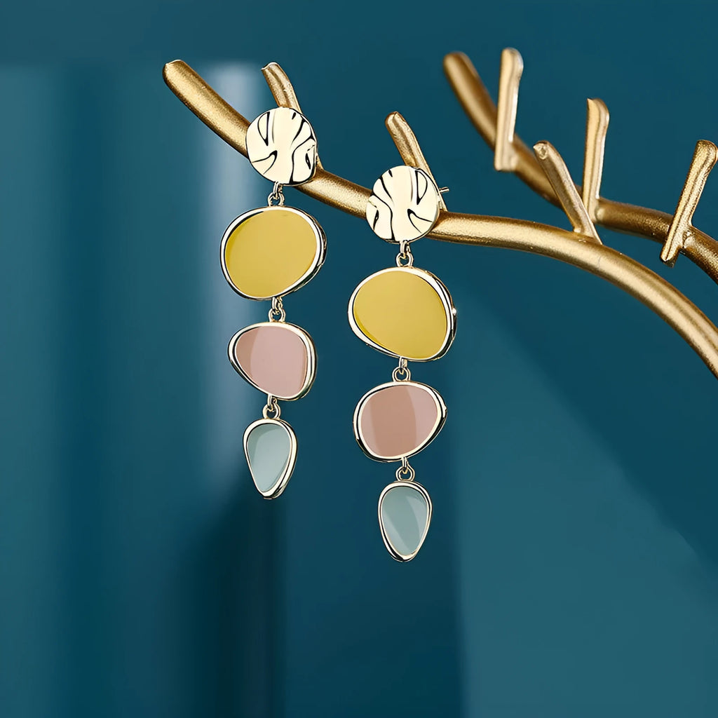 A pair of simple disc-shaped alloy earrings with a blended Morandi three-colour oil drip finish, showing a vintage wafer style.