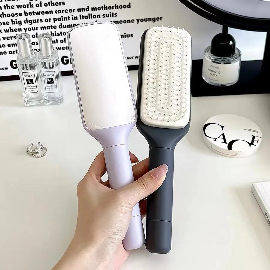 Roland purple self-cleaning hair brush with ergonomic handle showing rotating mechanism.