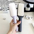 Roland purple self-cleaning hair brush with ergonomic handle showing rotating mechanism.