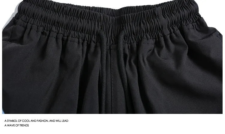 Black loose-fit quick-dry sports shorts with an elastic waistband on a manikin.
