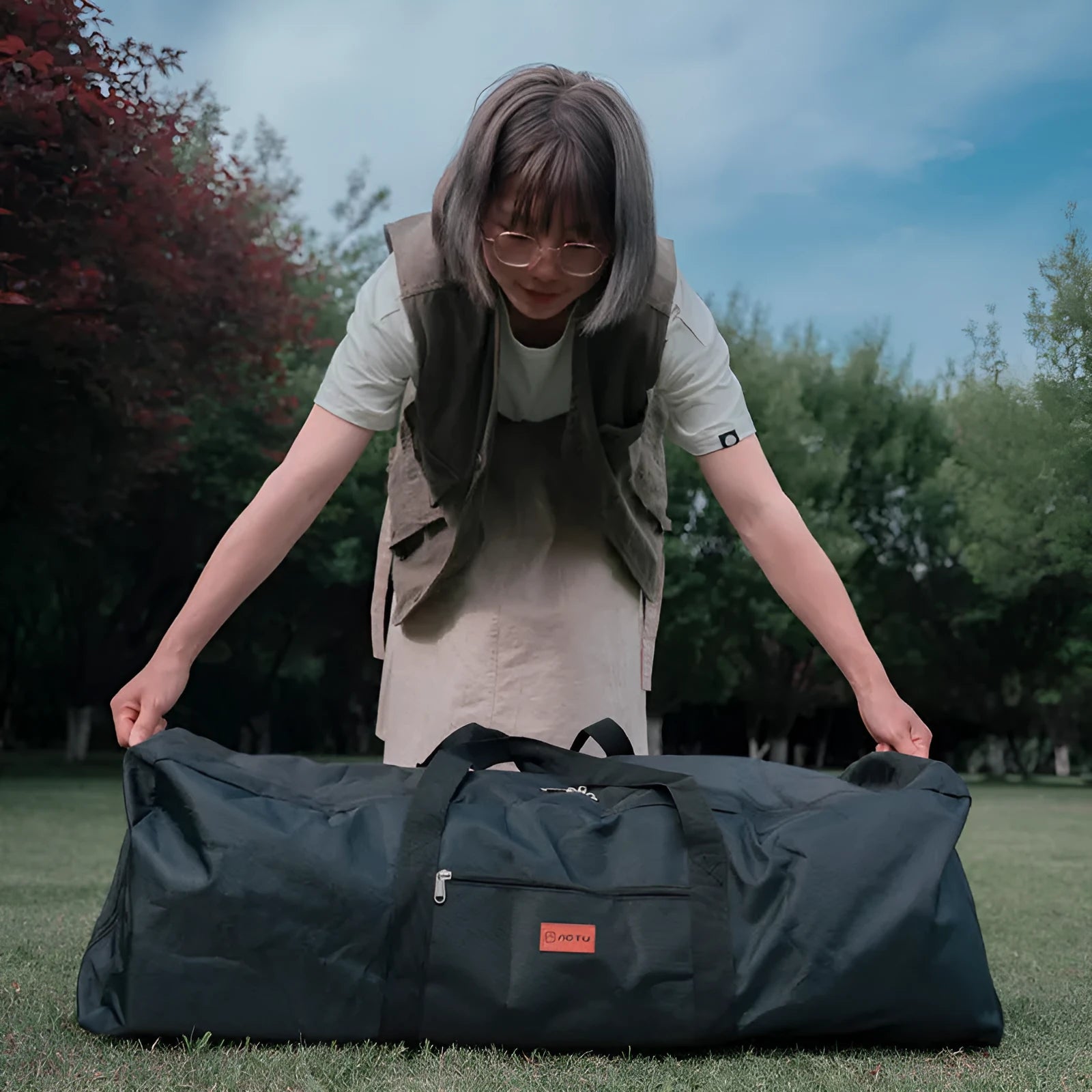 Green waterproof camping storage bag for folding tables and chairs showing expanded and folded sizes