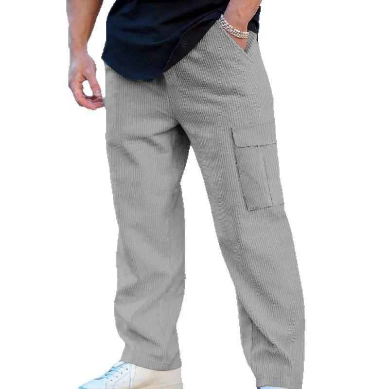 Man wearing navy blue loose-fitting corduroy cargo trousers with a drawstring waist and straight wide legs.