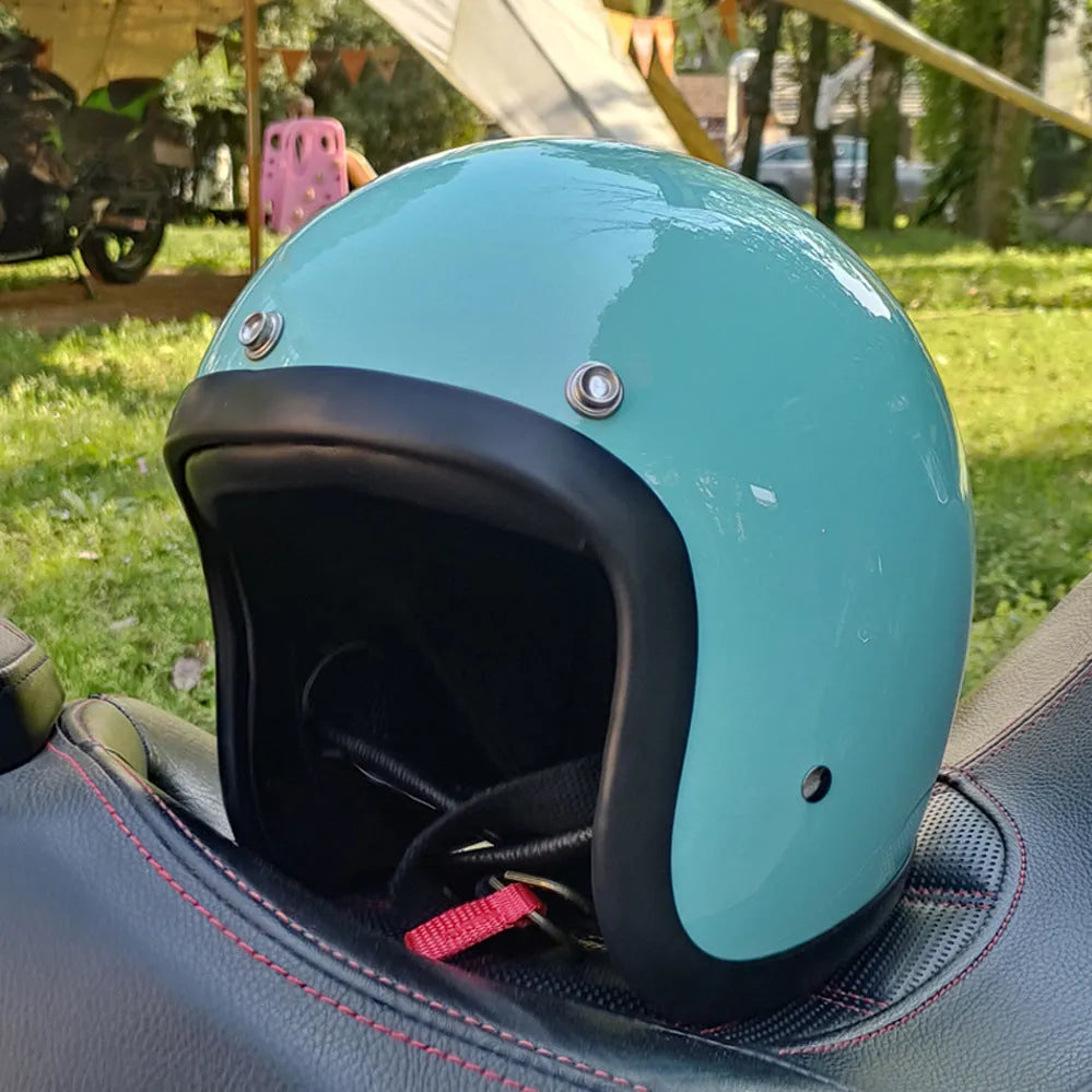 Cement grey retro half motorcycle helmet with glass fibre shell on a plain background.