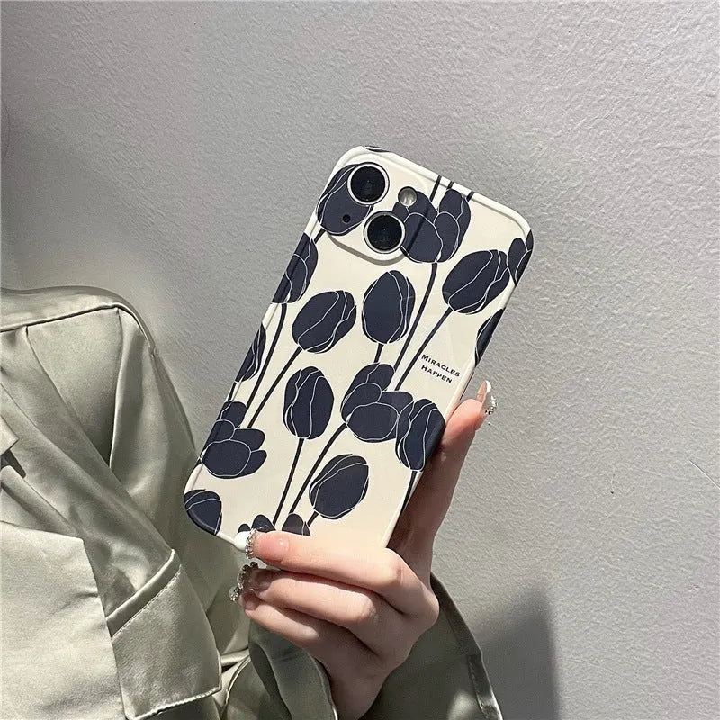 Black silicone iPhone case with a tulip pattern, shown on the back of a mobile phone.