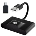 Wireless Android Auto adaptor for cars, shown in black, next to a car USB port.