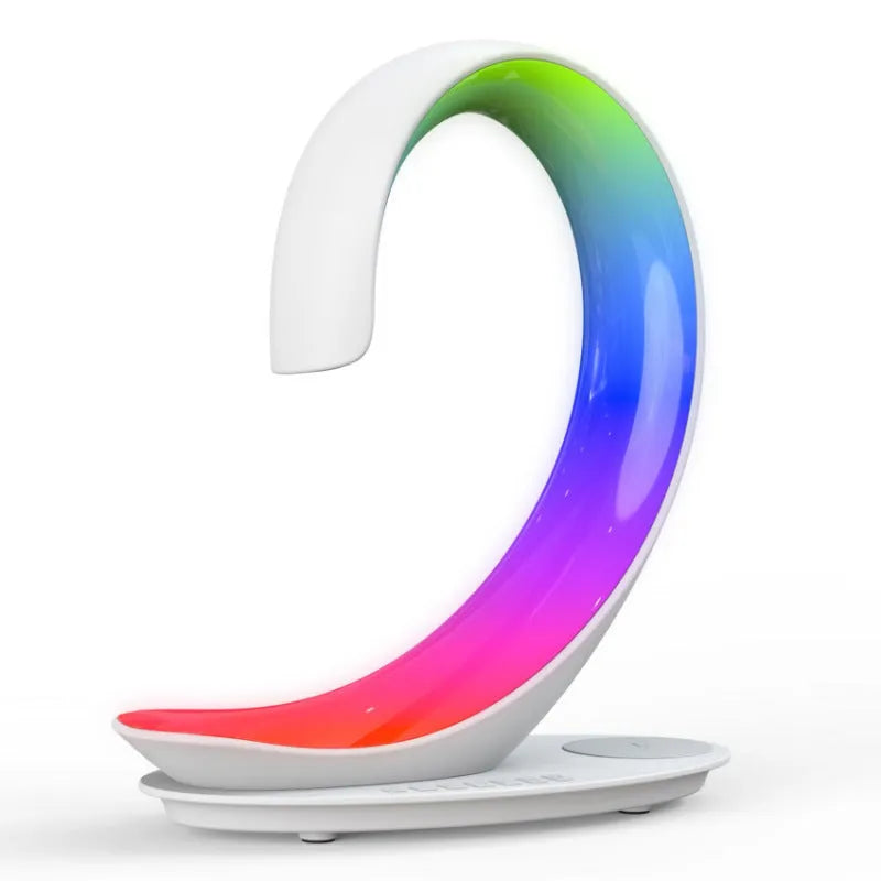White swan-shaped desk lamp with wireless charging base and Bluetooth speaker emitting colourful light.