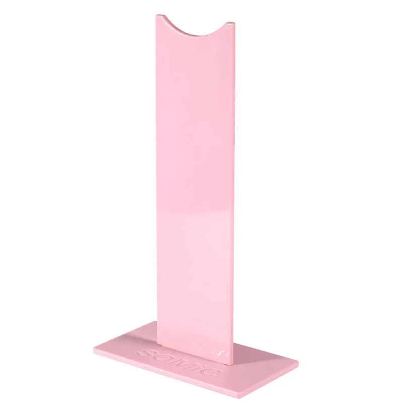 Black detachable head-mounted gaming headset stand with a silicone base on a wooden desk.