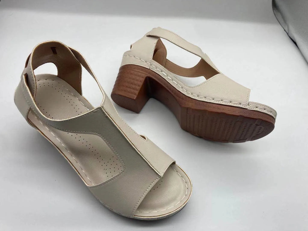 Women's white peep toe wedge sandals with a buckle and low heel on a neutral background.