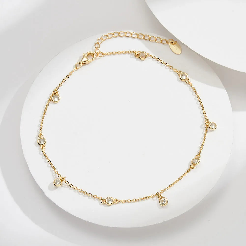 Silver women's anklet with a geometric pendant in a gold tone finish.