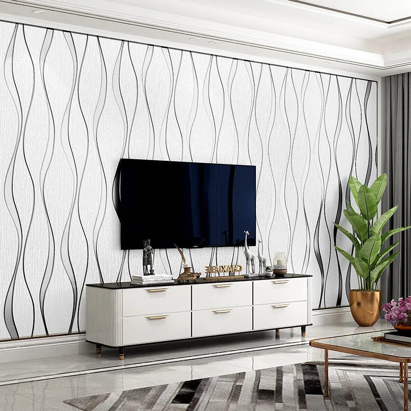 Roll of grey 3D curve stripe textured velvet wallpaper against a wall.