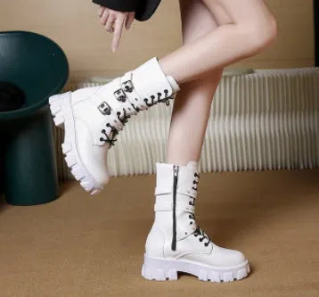 A pair of black mid-calf women's boots with metal buckle details and a side zipper on a white background.