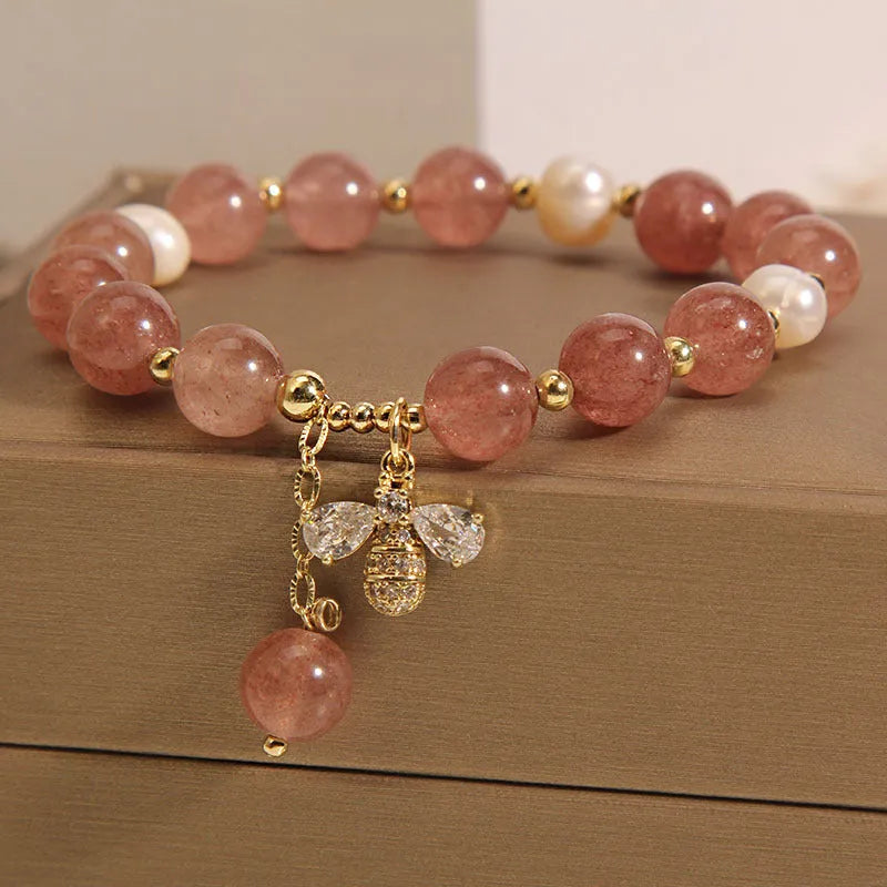 Women's freshwater pearl and strawberry quartz bracelet with zircon accents on wrist