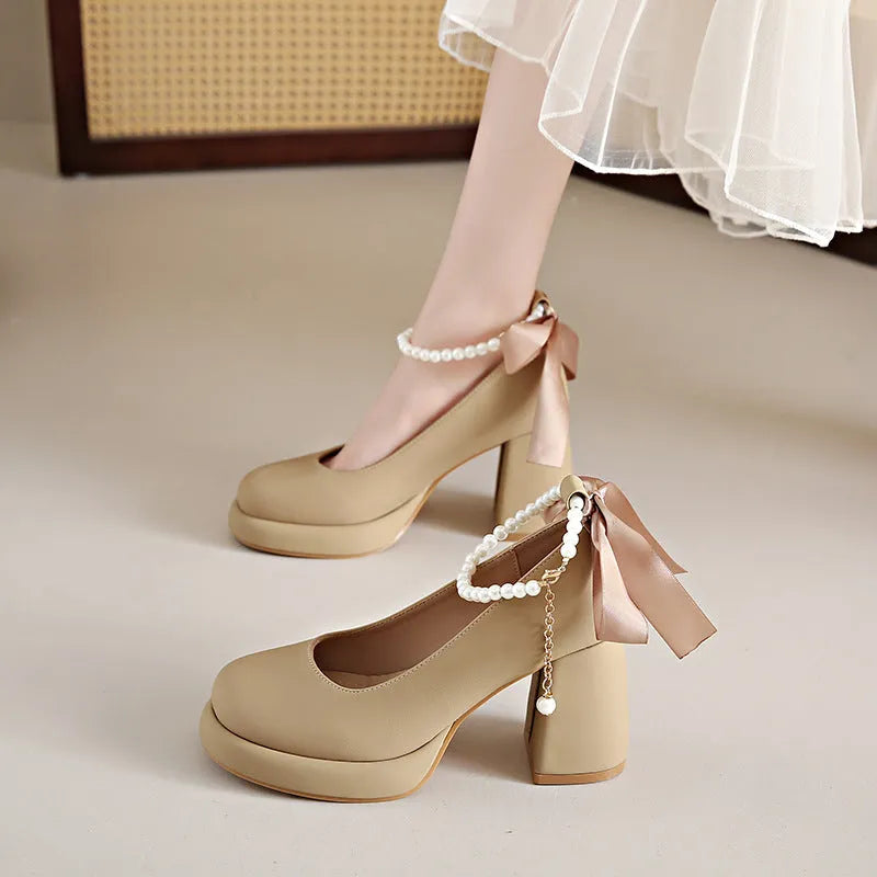 Beige women's Mary Jane shoes with a chunky heel and an ankle-strap buckle on a white background.
