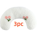 Small white blue yellow U-shaped plush pillow for cats and small dogs on a bed.