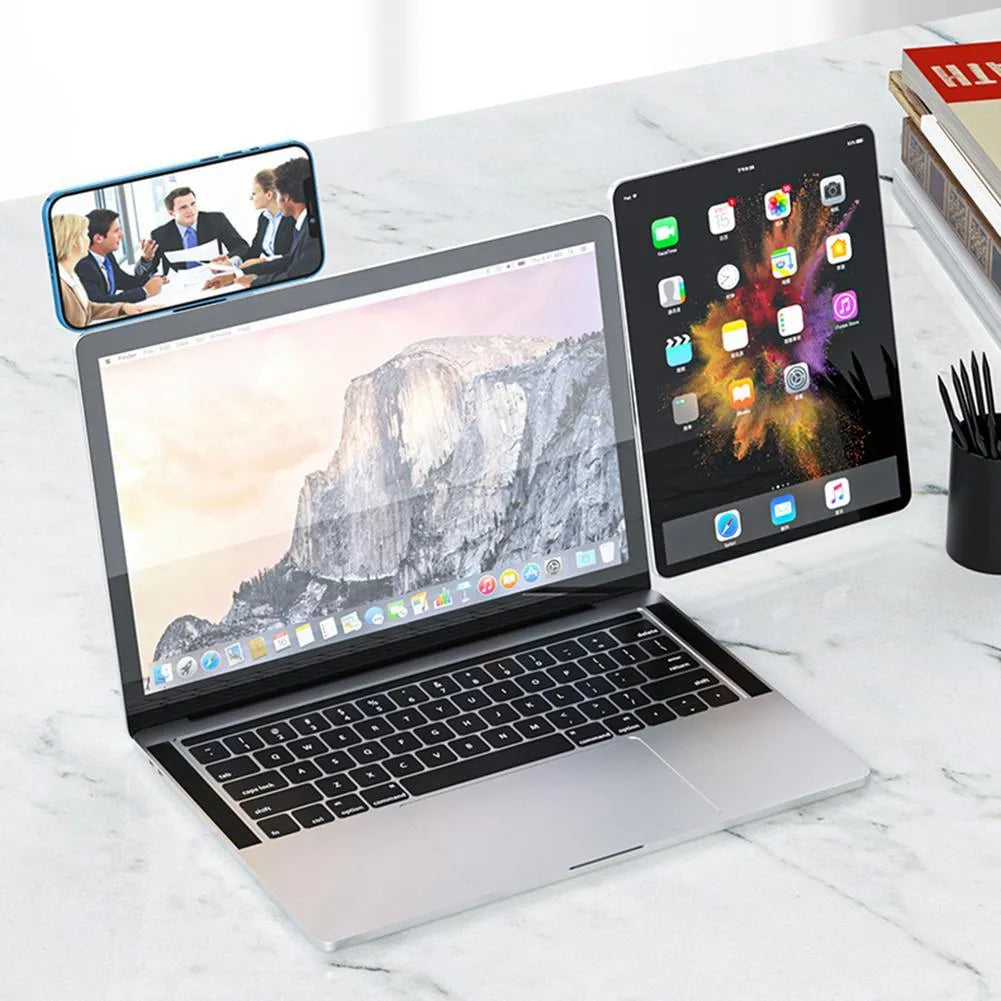 Black magnetic phone holder clipped to the side of a silver laptop, showing a smartphone attached.