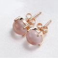 Rose gold coloured drop-shaped stud earrings with a synthetic ross quartz crystal inlay