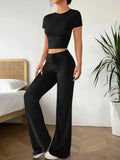 Black women's high waist trouser and short sleeve t-shirt co-ord set on a hanger.