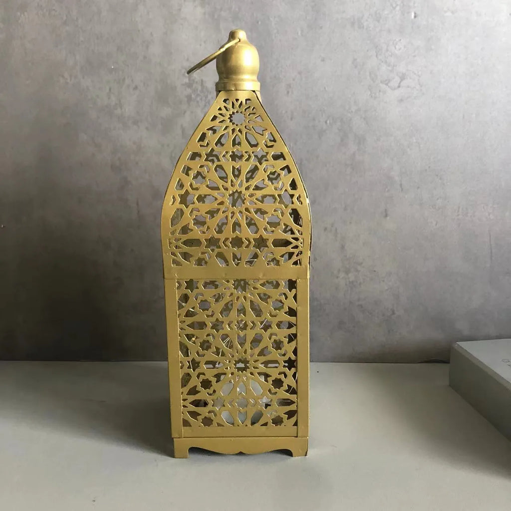 Gold L decorative iron barn lantern with hollow four-corner design on a tabletop