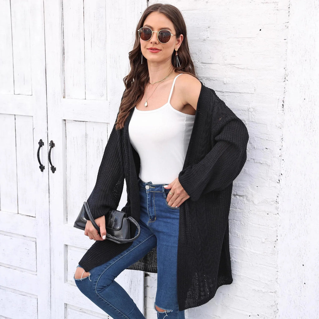 A woman's loose-fitting, solid-colour acrylic sweater coat on a hanger.