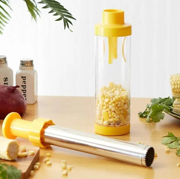 Yellow cylindrical corn stripper kitchen tool with stainless steel mechanism on a wooden surface.